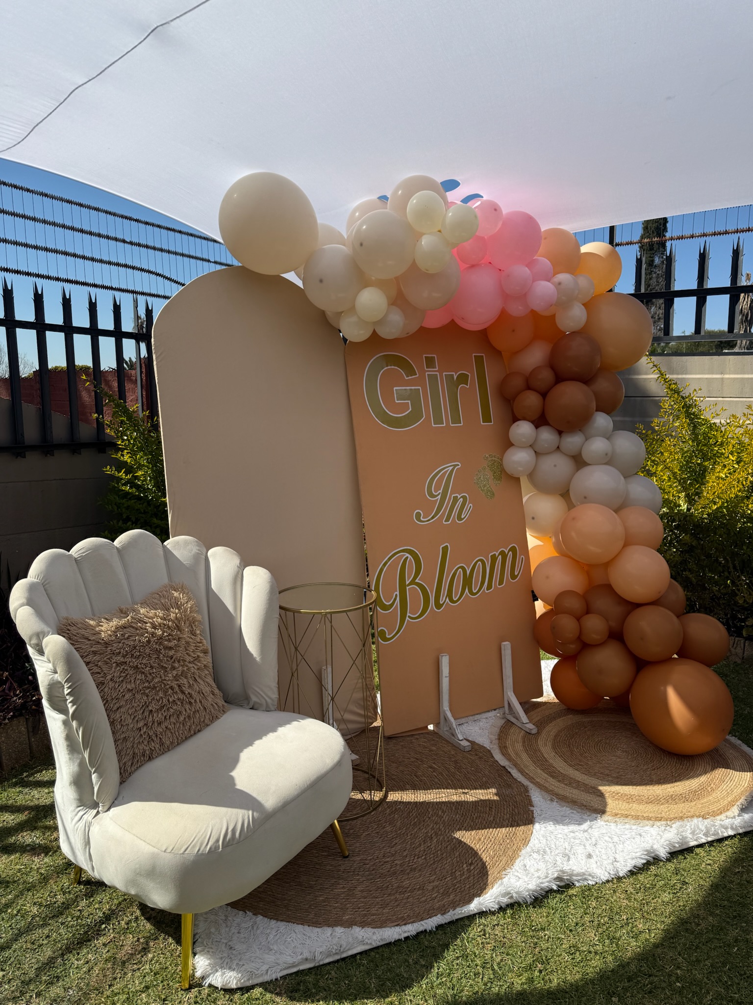 Low pallet picnic table styled with boho linens, florals, and cushions on green grass